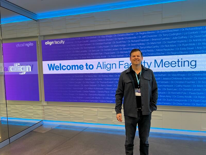 Man standing in front of the Align Welcome Wall.