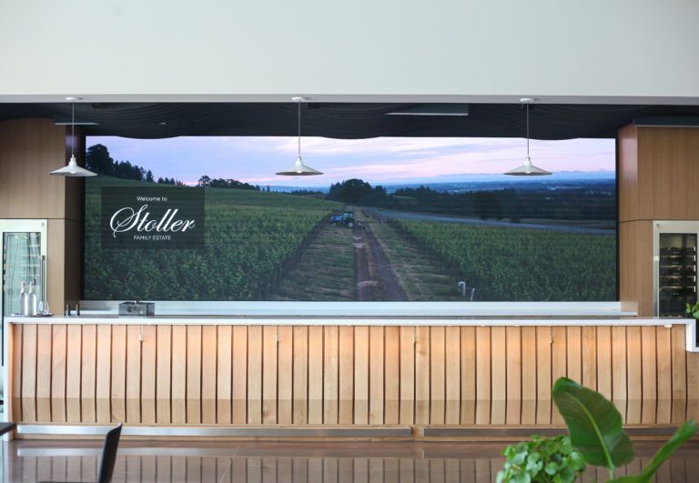A photo of the Stoller Virtual Barback screen behind a bar.